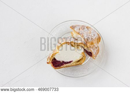Choux Bun With Whipped Cream, Cherry Jam And Sugar Powder On Top, Cutted In Half On Glass Plate, Whi
