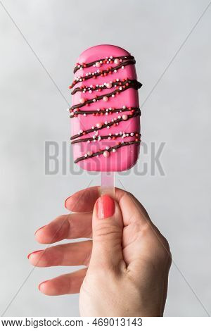 A Hand Holding A Homemade Decorated Cakesicle For Valentines Day.