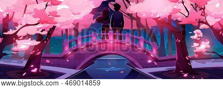 Love Couple Silhouettes On Illuminated Bridge In Night Urban Park With Blooming Sakura Trees. Man An