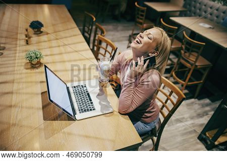 A Happy Remote Worker Is Sitting In Working Friendly Cafe And Having Business Call.