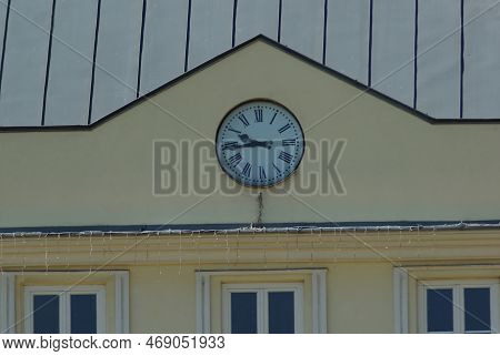 The Clock At The Town Hall In Checiny. The Clock On The Yellow Building Shows 9:45 Am. Spring Sunny 