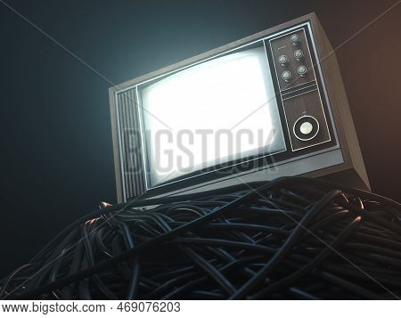 An Illuminated Vintage 80's Television Perched On A Jumbled Pile Of Black Cables On A Dark Omnious B