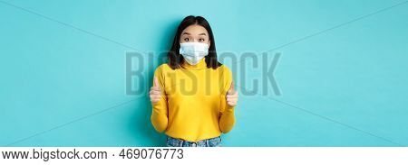 Covid-19, Social Distancing And Pandemic Concept. Excited Asian Woman Showing Thumbs Up And Looking 