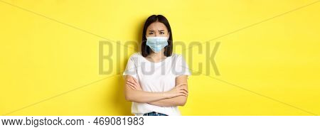 Covid, Health Care And Pandemic Concept. Asian Woman In White T-shirt And Medical Mask Cross Arms On