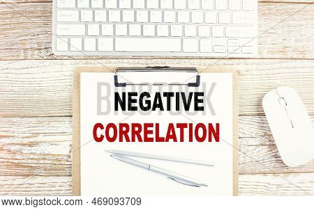Negative Correlation Text On A Clipboard With Keyboard On A Wooden Background