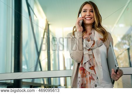 Outdoors Portrait Of Beautiful Young Business, Student Woman Laughing And Using Cell Phone