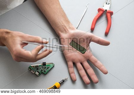 Robot Arm Concept. Man Shows Biomechanical Prosthetic Hand. Guy Repairs His Hand With Tool. Bioengin