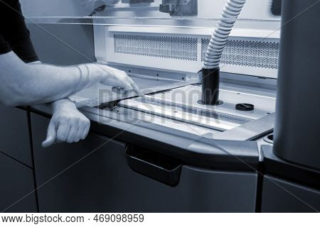 A Male Worker Stands Near The Powder Part Of A Powder 3d Printer And Points His Finger Of The Hand A