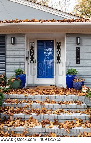 Close View Of Front Porch And Steps Of A Residential Home With A Deep Layer Of Fall Leaves, Leaf Lit