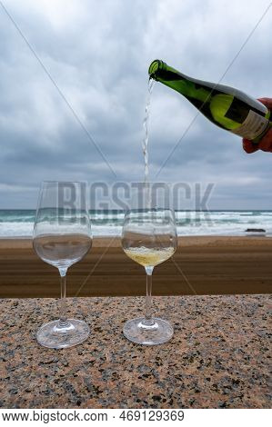 Pouring Of Txakoli Or Chacolí Slightly Sparkling Very Dry White Wine Produced In Spanish Basque Coun