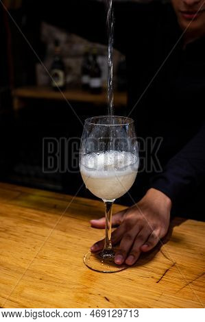 Pouring Of Txakoli Or Chacolí Slightly Sparkling Very Dry White Wine Produced In Spanish Basque Coun