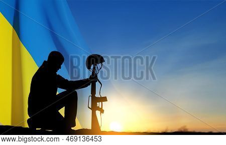 Flag Of Ukraine With Silhouette Of Soldier Kneeling Down Against The Sunset. Armed Forces Of Ukraine