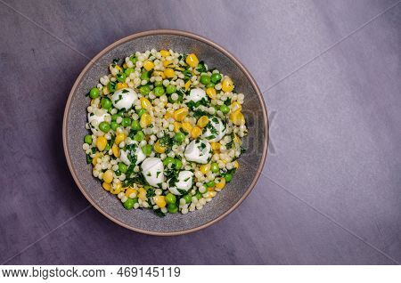 Salad Of Vegetables, Pasta And Mozzarella In A Dish On A Dark Background. Top View.