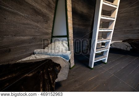 Single Beds With Clean Linen In Niches Of Wooden Cabin. Pyramid Shape Bungalow Summer House. Angled 