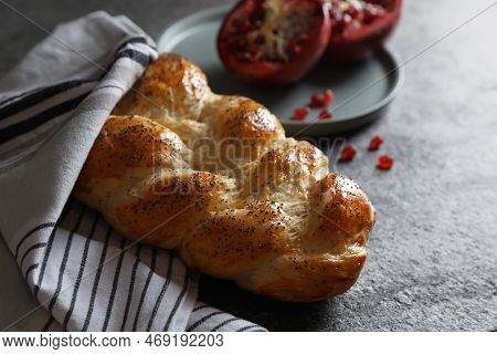 Homemade Braided Bread And Pomegranate On Grey Table. Cooking Traditional Shabbat Challah