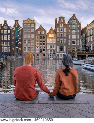 Amsterdam Canals In The Evening, Couple Men And Women On A City Trip In Amsterdam