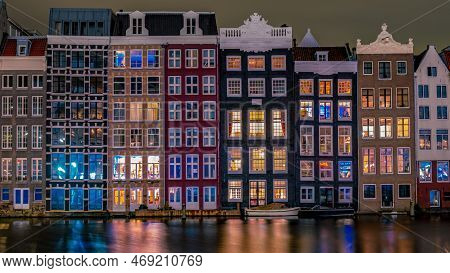 Amsterdam At Night With Dancing Colorful House At The Amsterdam Canals