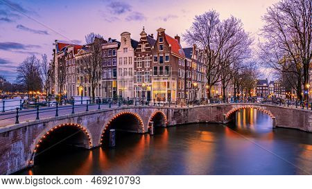 Amsterdam At Night With Dancing Colorful House At The Amsterdam Canals
