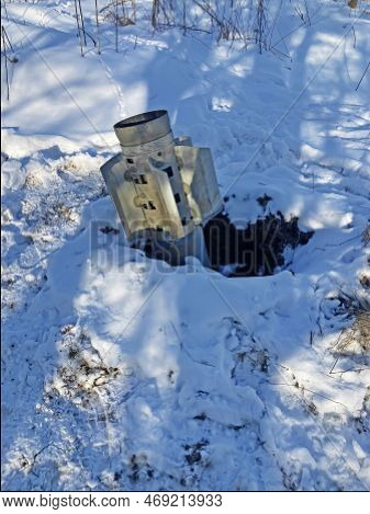 The Tail Of A Rocket Sticking Out Of The Snow. Unexploded Shell. Rocket From Grad Stuck In The Groun