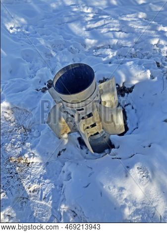 The Tail Of A Rocket Sticking Out Of The Snow. Unexploded Shell. Rocket From Grad Stuck In The Groun