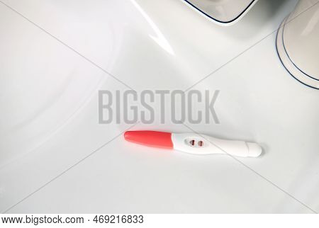 View From Above. Selective Focus On An Inkjet Pregnancy Test In Action With Positive Result On A Whi