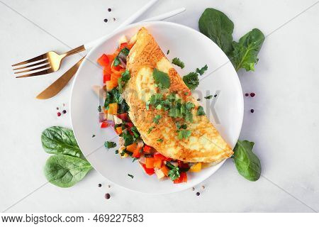 Healthy Vegetable Loaded Omelette. Top Down View Table Scene Over A White Marble Background.