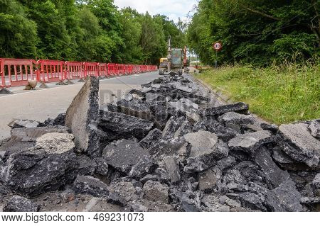 Excavator With Hydraulic Jack Hammer  Breaking Asphalt In Preparation For Drainage Works Close Up An