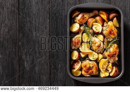 Lemon Garlic Chicken With Roasted Potatoes, Spices And Herbs On Sheet-pan On Dark Wood Table, Horizo