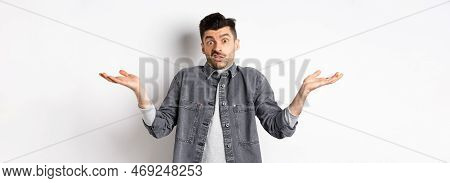 I Dont Know. Clueless Young Man Shrugging And Looking Confused, Have Nothing To Say, Standing Unawar