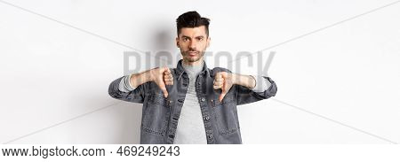 Very Bad. Serious Man Showing Thumbs Down And Look At Camera With Pokerface, Telling No, Disapprove 