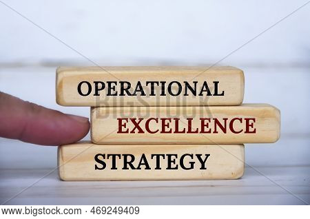Hand Pointing Operational Excellence Strategy Text On Wooden Blocks. Operational Excellence And Busi