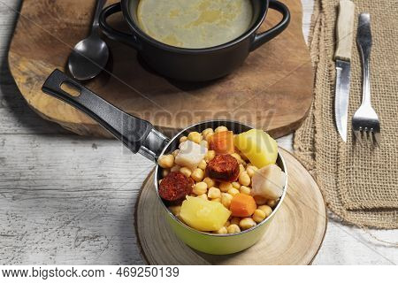 Cooked (cocido, Guiso) Stew, Chickpeas With Chorizo, Bacon, Carrot And Potato In Green Saucepan, Bla
