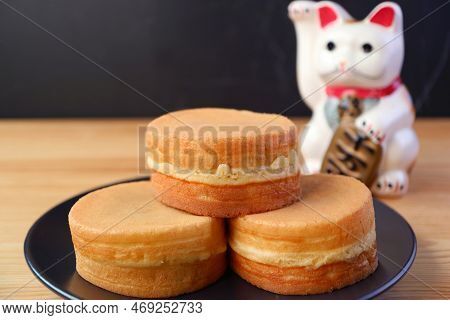 Stack Of Imagawayaki Or Obanyaki, Japanese Traditional Filling Pan Cakes With Beckoning Cat Maneki-n