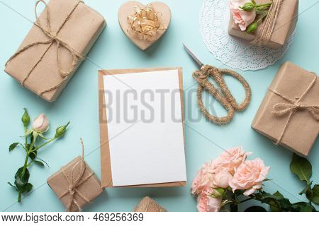Flatline Valentines Day. A Bouquet Of Bush Roses And A Gift In Kraft Paper On A Light Blue Backgroun