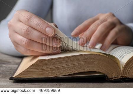 Woman Reading Bible At Wooden Table, Closeup