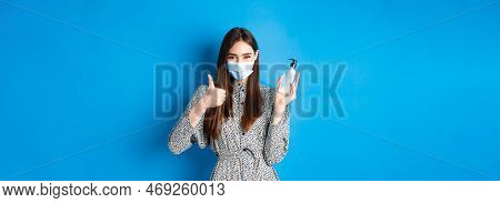 Covid-19, Social Distancing And Healthcare Concept. Beautiful Girl In Medical Mask Using Hand Sanizi