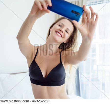 Young Sexy Woman Posing In Front Of Smartphone In His Hand And Working As Webcam Model