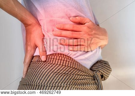 Asian Young Man Suffering From Back And Loin Pain. It Can Be Caused By Renal Stone.