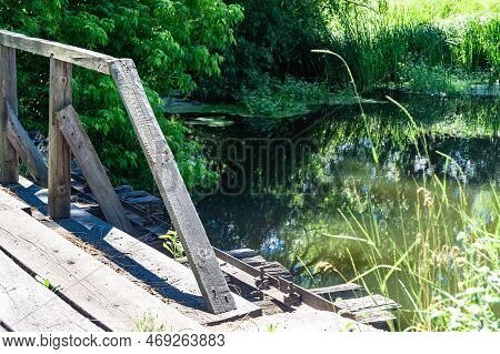 Beautifully Standing Old Wooden Bridge Over River In Colored Background Close Up