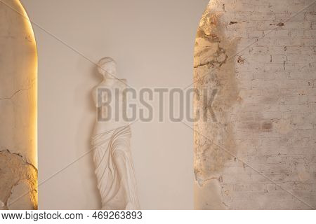 Venus Statue In Antique Interior Next To White Wall