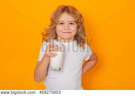 Child With Glass Of Milk On Studio Yellow Background. Kid With Milk Moustache. Fun Portrait Of Cute 