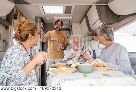 Happy Group Of Caucasian Multigenerational Family Sitting Inside A Camper Van Motorhome Dinette Hugg