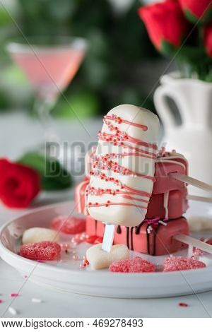A Homemade Valentine Cakesicle Leaning Against A Pile Of Other Cakesicles.