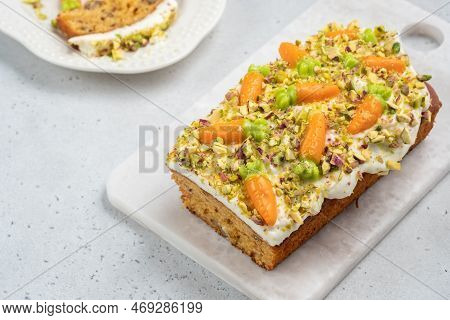 Carrot Loaf Cake With Walnuts Decotated With Cream Cheese, Candy Carrot And Pistachios