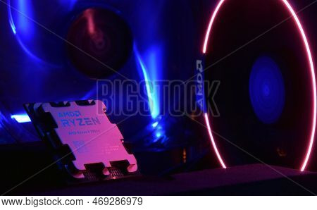 Close-up Of An Amd Ryzen 9 3900X Processor, Against The Backdrop Of Coolers With Light.