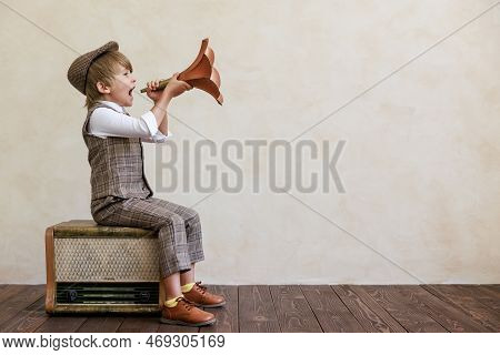 Newsboy Shouting Against Grunge Wall Background. Boy Selling Newspaper
