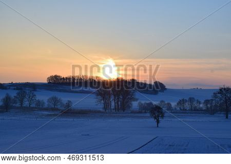 Orange Sunrise Above The Snow Covered Eifel Landscape