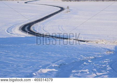 Curvy Road In The Snow Covered Mountains