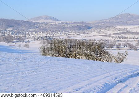 Snow Covered Eifel Landscape With Villages And Volcano Hills
