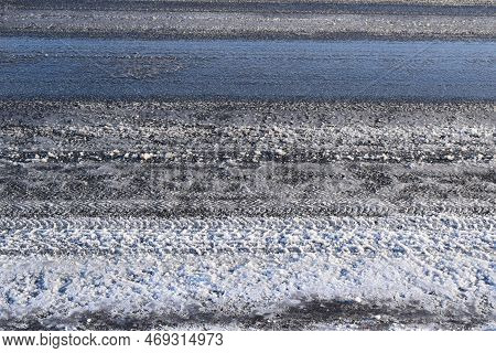 Some Remaining Snow On The Road With Tire Tracks